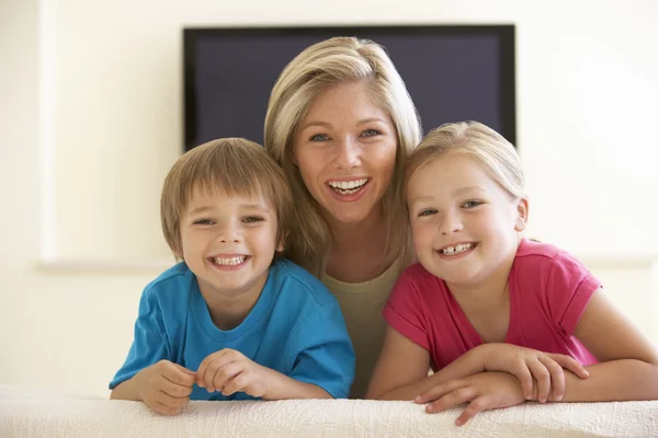 Мама и дети смотрят телевизор дома — стоковое фото