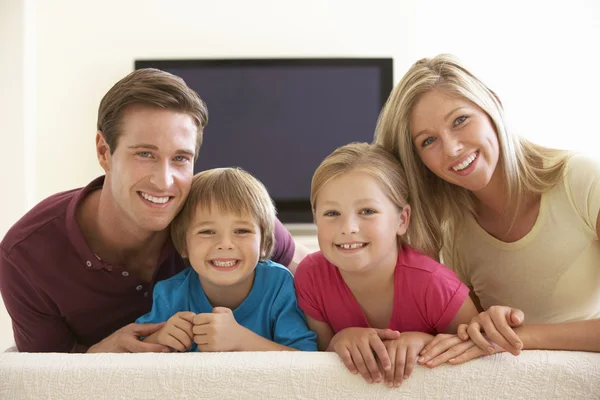 Familia viendo televisión de pantalla ancha en casa — Foto de Stock