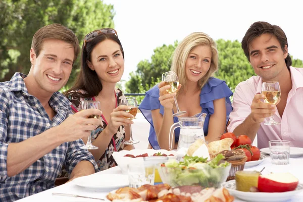 Grupp vänner njuter måltid tillsammans — Stockfoto