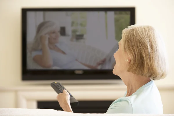 Anziana donna guardando widescreen TV — Foto Stock