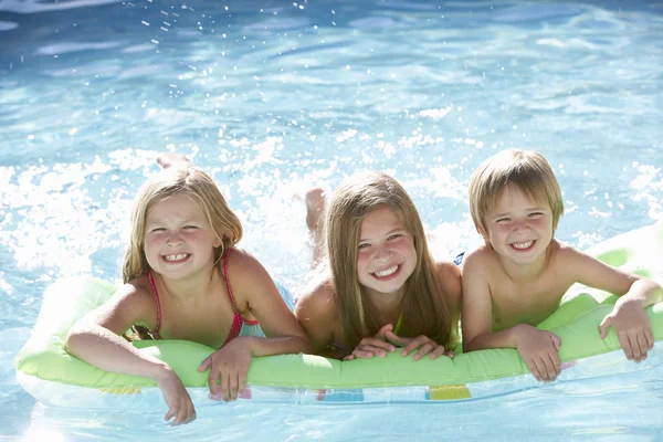 Дети отдыхают в бассейне вместе — стоковое фото
