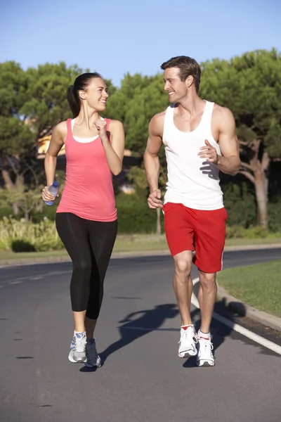 Pareja joven corriendo por la carretera —  Fotos de Stock