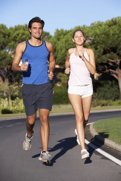 Jeune couple courant sur la route — Photo