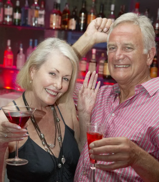 Pareja mayor disfrutando de bebidas en el bar — Foto de Stock