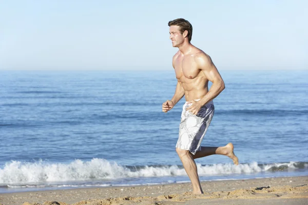 Uomo che corre lungo la spiaggia — Foto Stock