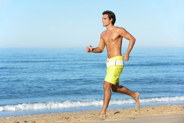 Homme courant le long de la plage — Photo