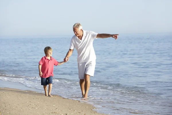 Opa en kleinzoon wandelen langs strand — Stockfoto