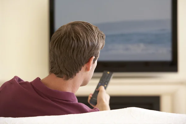 Mann schaut Breitbild-Fernsehen lizenzfreie Stockbilder