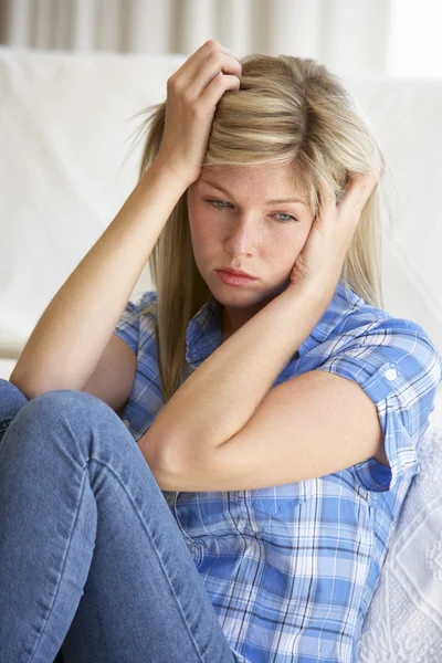 Mujer joven deprimida en casa Imagen de stock