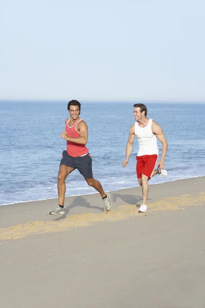 Hommes jogging le long de la plage — Photo