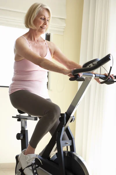 Senior mulher em bicicleta de exercício — Fotografia de Stock