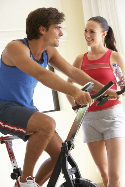 Pareja joven en bicicleta de ejercicio —  Fotos de Stock