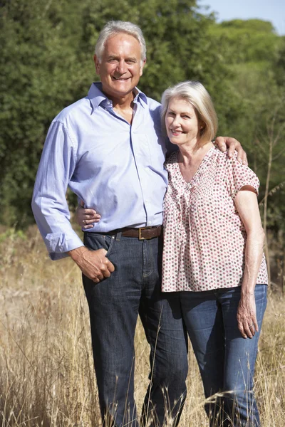 Pareja mayor caminando por el campo — Foto de Stock