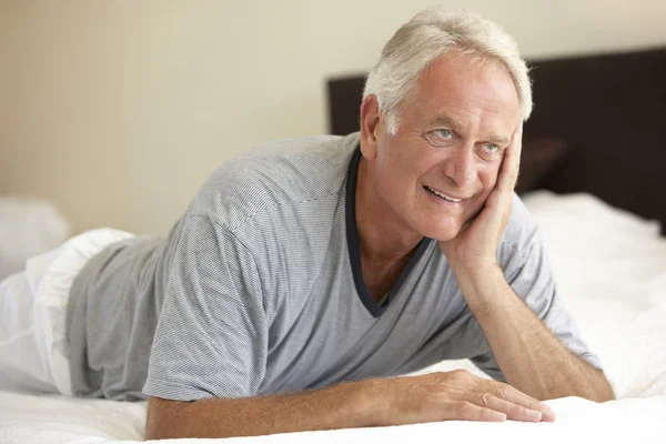Пенсионер, отдыхающий на кровати — стоковое фото