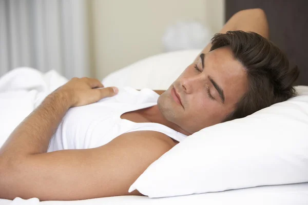 Jonge man ontspannen in bed — Stockfoto