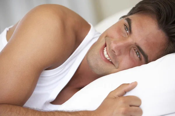 Jonge man ontspannen in bed — Stockfoto