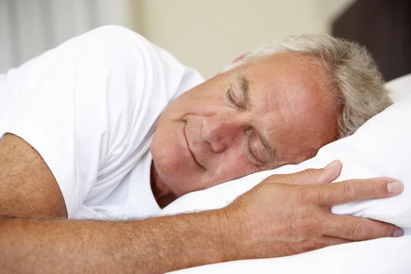 Пожилой человек спит в кровати — стоковое фото