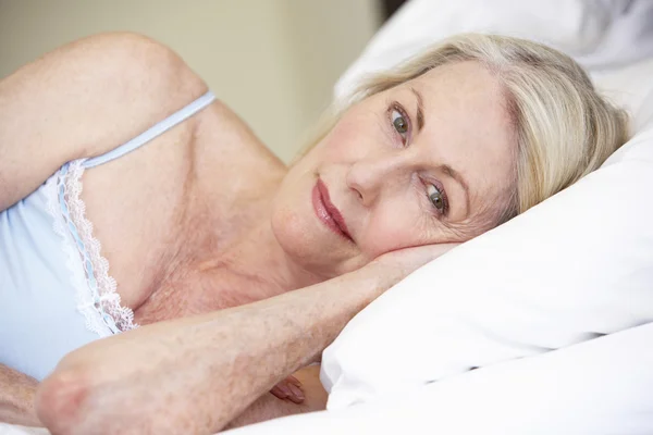 Senior vrouw ontspannen op bed — Stockfoto