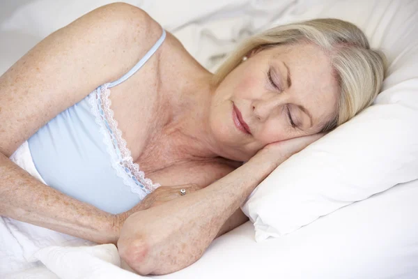 Seniorin schläft im Bett — Stockfoto