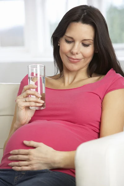 Donna incinta che beve bicchiere d'acqua — Foto Stock