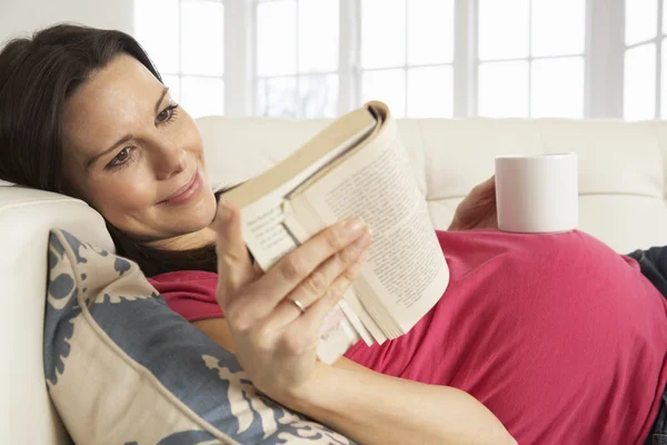 Беременная женщина читает книгу — стоковое фото