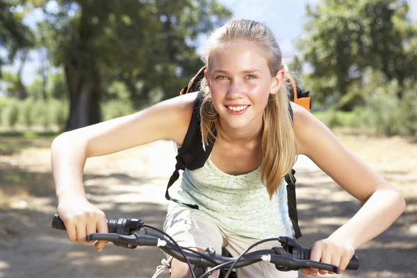 Ragazza adolescente in bicicletta attraverso la campagna — Foto Stock