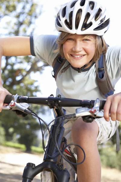 Adolescente menino de bicicleta através do campo — Fotografia de Stock