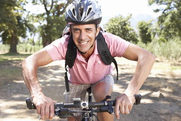 Homme faisant du vélo à travers la campagne — Photo