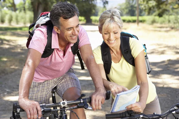 Casal de bicicleta através do campo — Fotografia de Stock