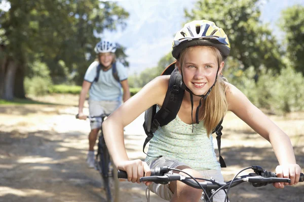 Casal de bicicleta através do campo — Fotografia de Stock