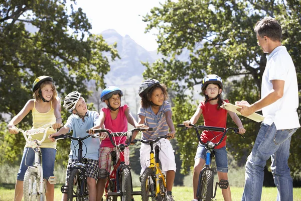 群骑自行车在农村的孩子 — 图库照片