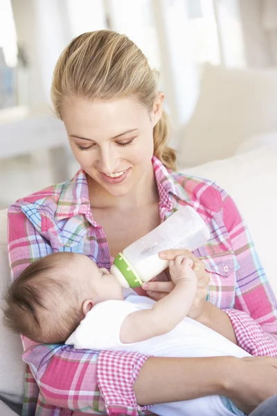 Mãe com bebê alimentando no sofá — Fotografia de Stock