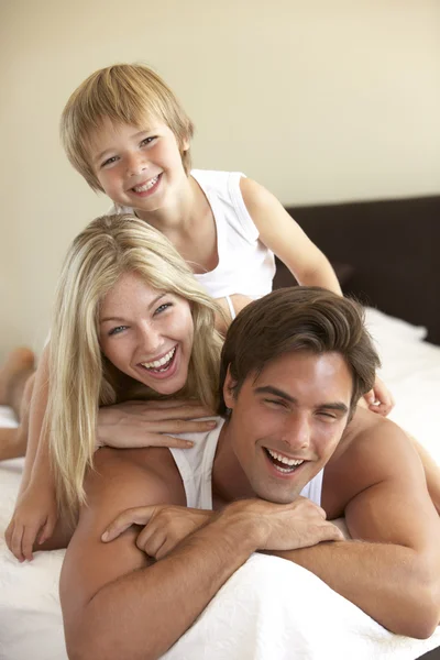 Jovem família relaxante na cama — Fotografia de Stock