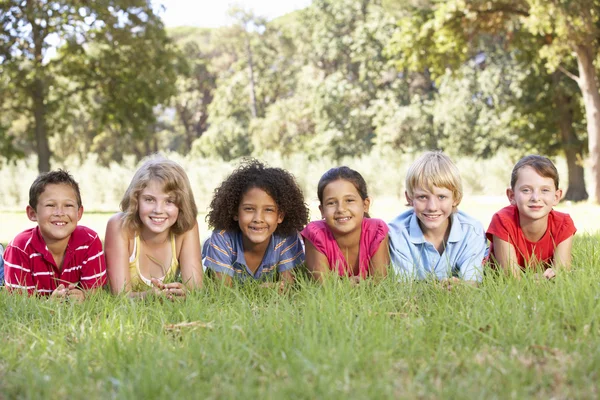 Groep kinderen ontspannen op platteland Stockfoto