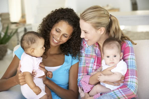 Madres jóvenes en el sofá en casa — Foto de Stock