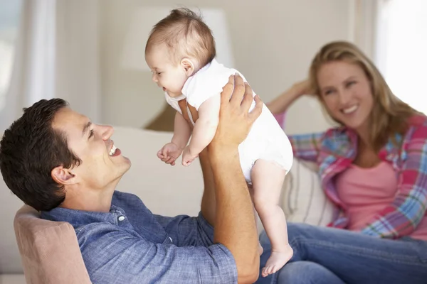 Familia joven en el sofá en casa — Foto de Stock