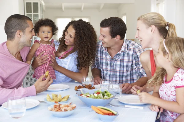 Familias disfrutando de la comida en casa — Foto de Stock