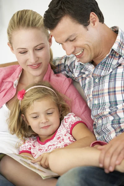 Eltern lesen mit Tochter zu Hause — Stockfoto