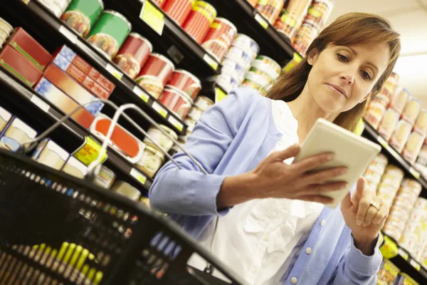 Frau kauft im Supermarkt ein — Stockfoto