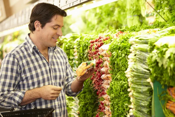 Чоловік купує продукцію в супермаркеті — стокове фото