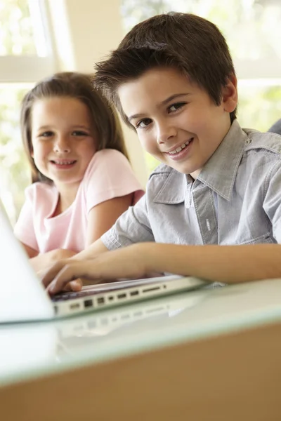 Pojke och flicka med laptop — Stockfoto