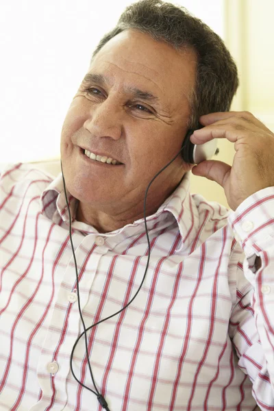 Senior man met een koptelefoon — Stockfoto