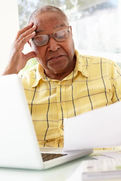 Hombre mayor estudiando papeleo en casa — Foto de Stock