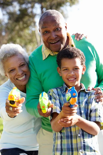 Nonni e nipote che sparano pistole ad acqua — Foto Stock