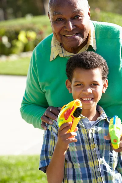 Nonno e nipote sparare pistole ad acqua — Foto Stock