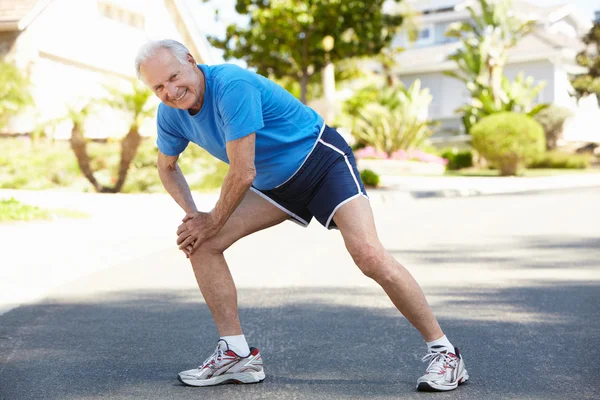 Älterer Mann wärmt sich für Lauf auf — Stockfoto