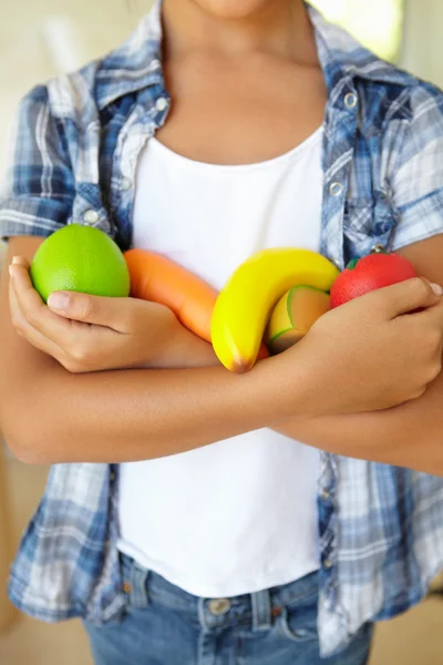 Ragazza che tiene frutta e verdura di plastica — Foto Stock