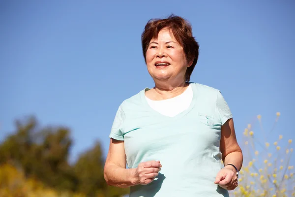 Donna anziana che corre in campagna — Foto Stock