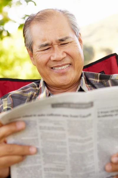 Senior Aziatische man lezing krant — Stockfoto