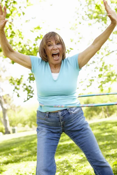 Mujer mayor con aro hula en el parque — Foto de Stock